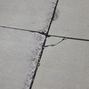 Spalling at concrete pavement control joint.