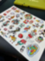 A close-up display of an original hand-painted Friday the 13th tattoo flash sheet full of classic micro-sized traditional designs.