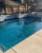 Custom swimming pool with blue water, stone walls