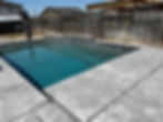 Custom swimming pool design with stone coping and tile wall