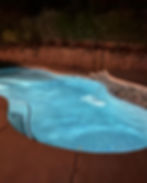 Custom swimming pool designs with glowing water at night