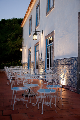 Mesas dispostas no terraço e parede com azulejos