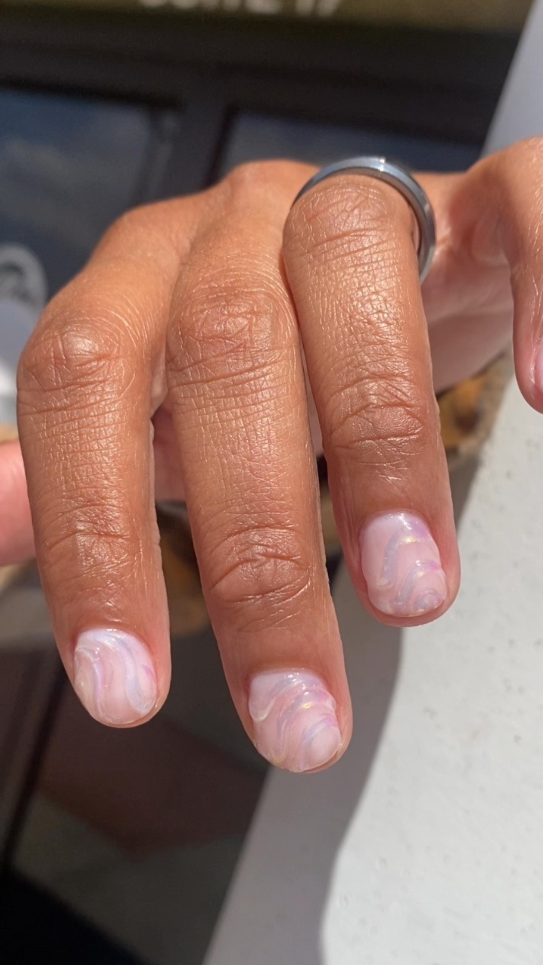 Man with 3D iridescent swirled nail art.