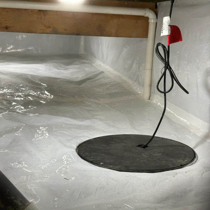 A sealed crawl space with a vapor barrier and a sump pump installed to prevent moisture and water intrusion.
