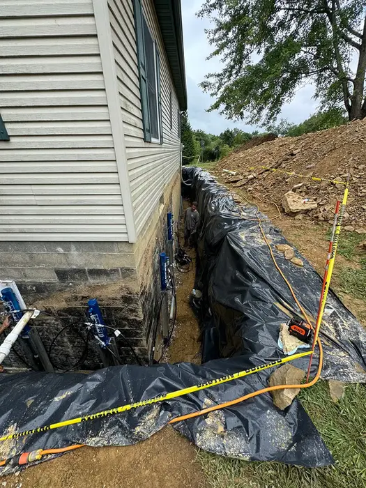 An exterior foundation repair project with hydraulic push piers installed to stabilize and lift a settling home.