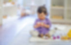 Toddler child on the rug opening an oval toy