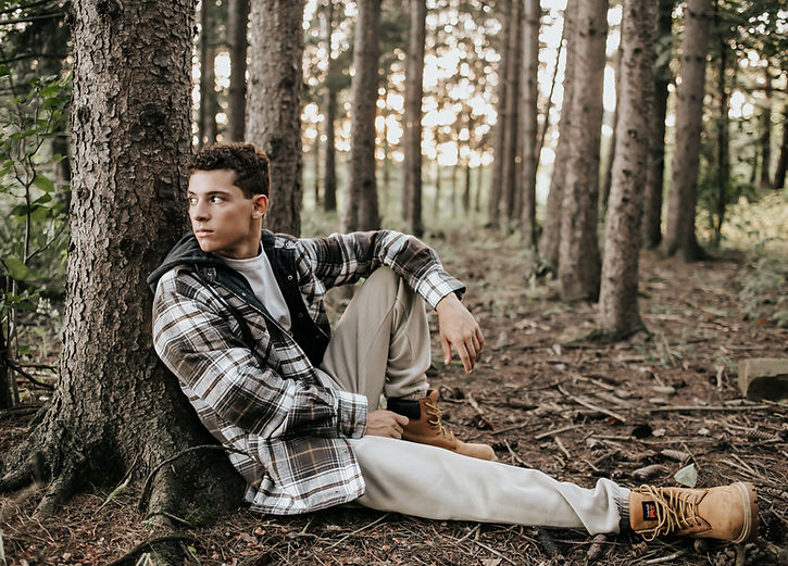 a high school senior boy in the woods
