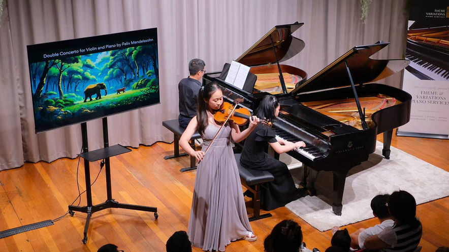 Two grand pianos and a violin during a Concerts for All Storytelling concert.