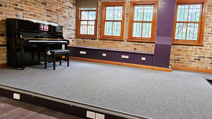 An upright piano in a 40 sqm rehearsal space