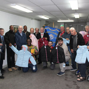 Men displaying children's coats.