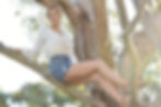 An editorial style portrait of a women sitting in a tree. Back lit portrait using natural light. Taken at Margaret Lewis Reserve in Coldstream.