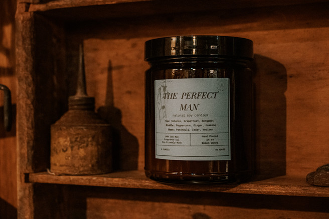 Rustic product photography of a handmade soy wax candle called "The Perfect Man."