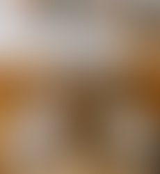 A college student sitting at her dorm desk with her head back and a book opened on her head
