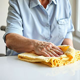 a disabled adulte person wiping clear folders clean with a rag .jpg