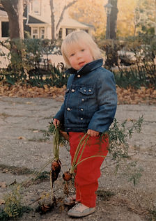 A vintage photo of a todler holding a carrot