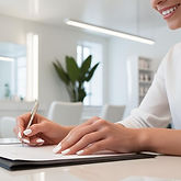 close up shot of a womans hands while she is filling out a consultation form in a modern s