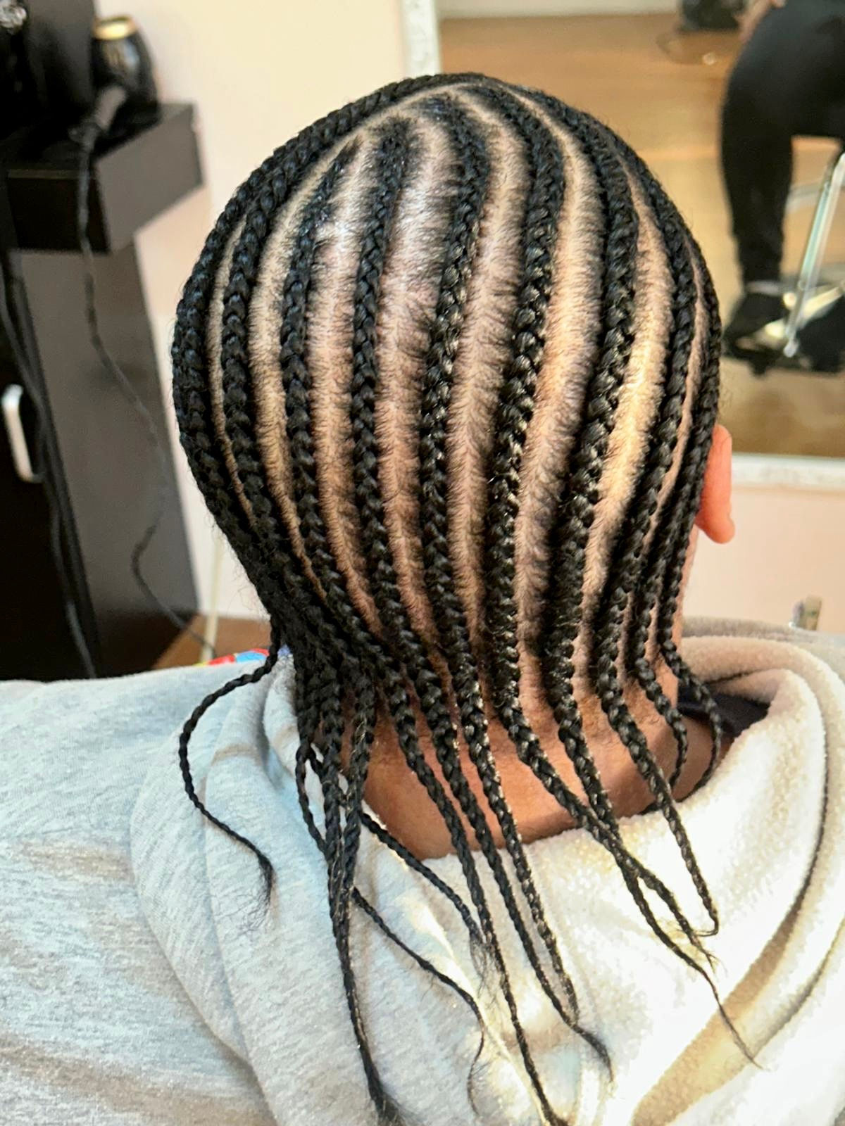 back view of straight back basic cornrows without extensions, styled at Unique braids and weaves hair salon, Houston, Texas