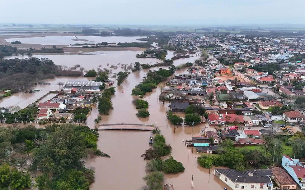 Enchente em São Lourenço do Sul após fortes chuvas, com ruas alagadas e equipes de emergência em atuação.