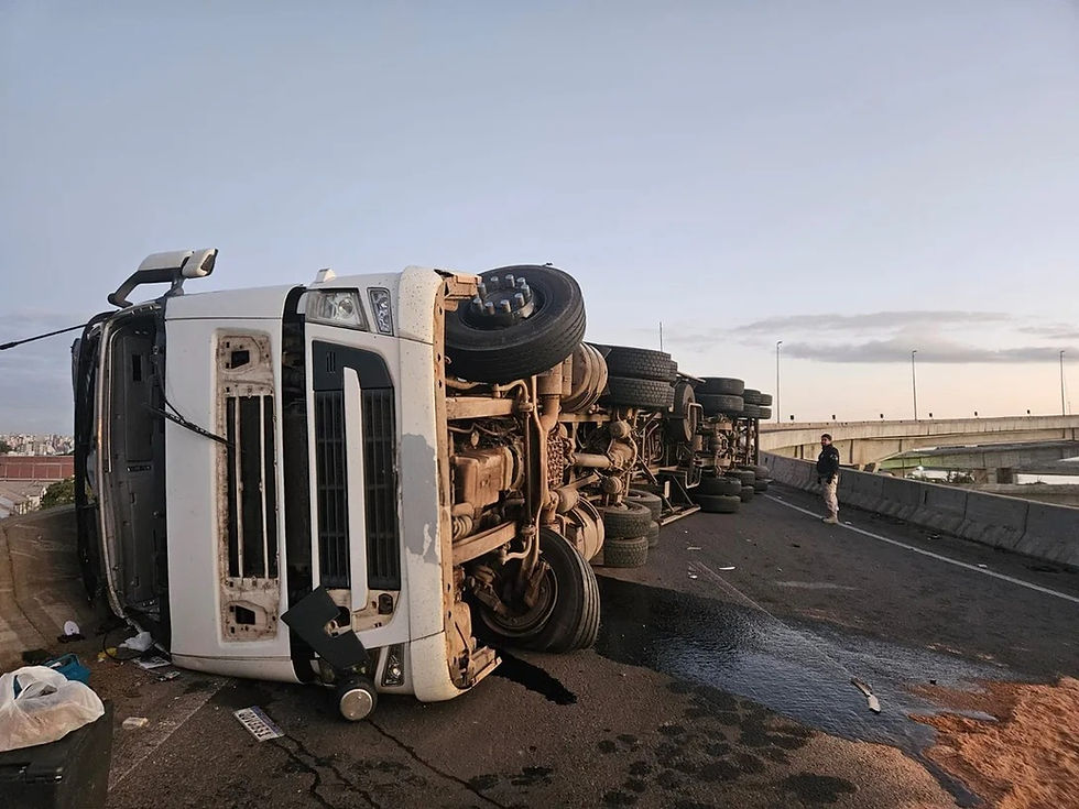Imagem mostra caminhão tombado na alça da ponte nova do Guaíba, com carga espalhada sobre a pista e equipes de resgate no local