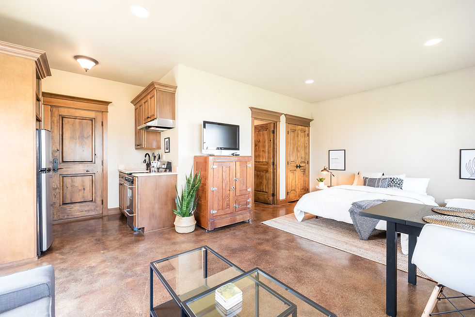 Image is of separate unit or room with a bed, fridge, and other small amenities as a rental property for the blog Is It Worth it to Buy a Rental Property Right Now?