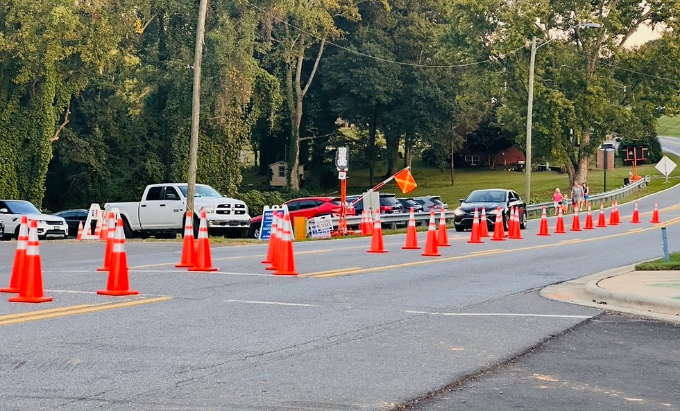 The gate-arm with the orange flag raises for the car to pass by during an unusual light traffic moment.