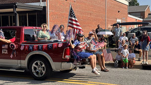 Crime Stoppers parade entry drives by waving at the crowd