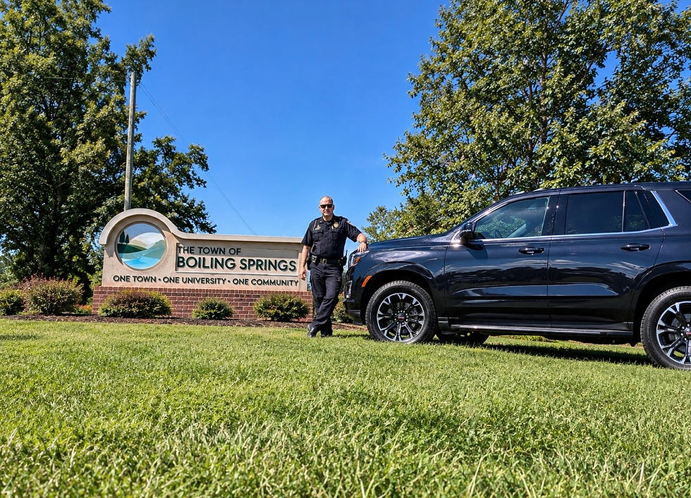 Chief DiYorio next to his police vehicle and the Welcome sign to Boiling Springs, NC.