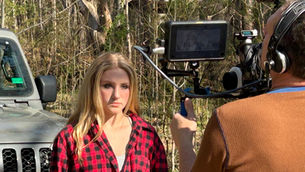 the movie production behind the scenes of the cameraman shooting a scene with an actress in front of the camera
