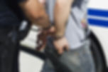 cop holding man in handcuffs