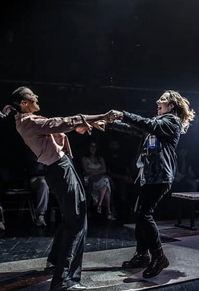 Two actors holding arms