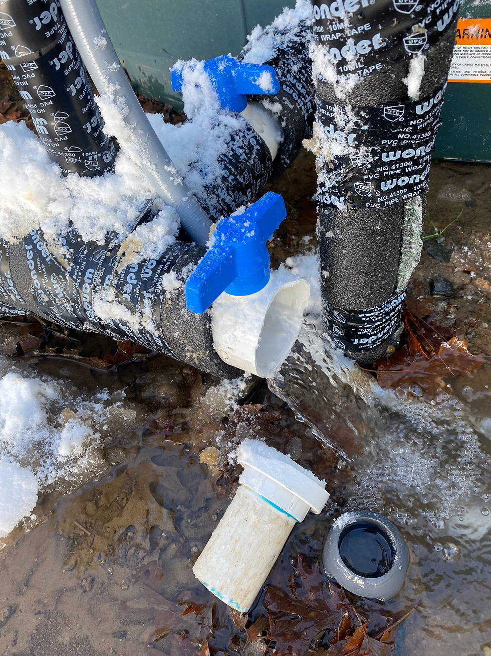 Broken irrigation pipe in snow-covered conditions, flooding water onto the ground due to winter freeze damage in a commercial cannabis facility.
