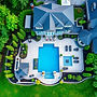 A beautiful ariel view of a luxurious backyard in Oakville, Ontario with a pool and landsc