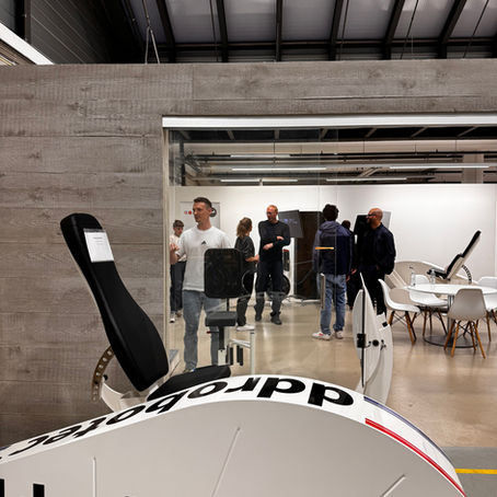 Blick in den Showroom von ddrobotec, in dem mehrere Menschen die Trainingsgeräte betrachten und sich austauschen.