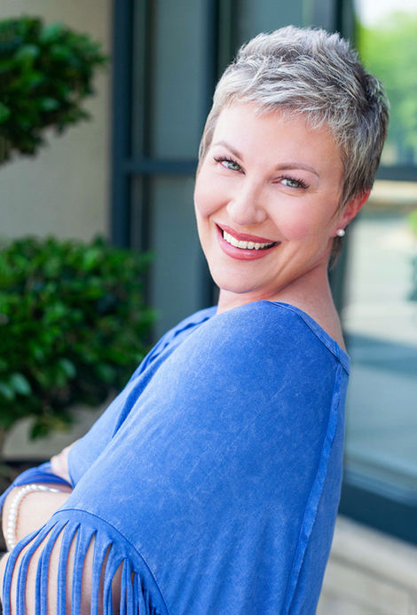 Professional Headshot of a gray haired middle aged women smiling at the camera.