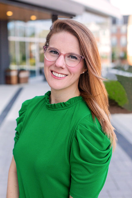 An outdoor professional headshot shoot by A Brew and You in Charlotte NC, the women in the image is wearing a green blouse and smiling at the camera 