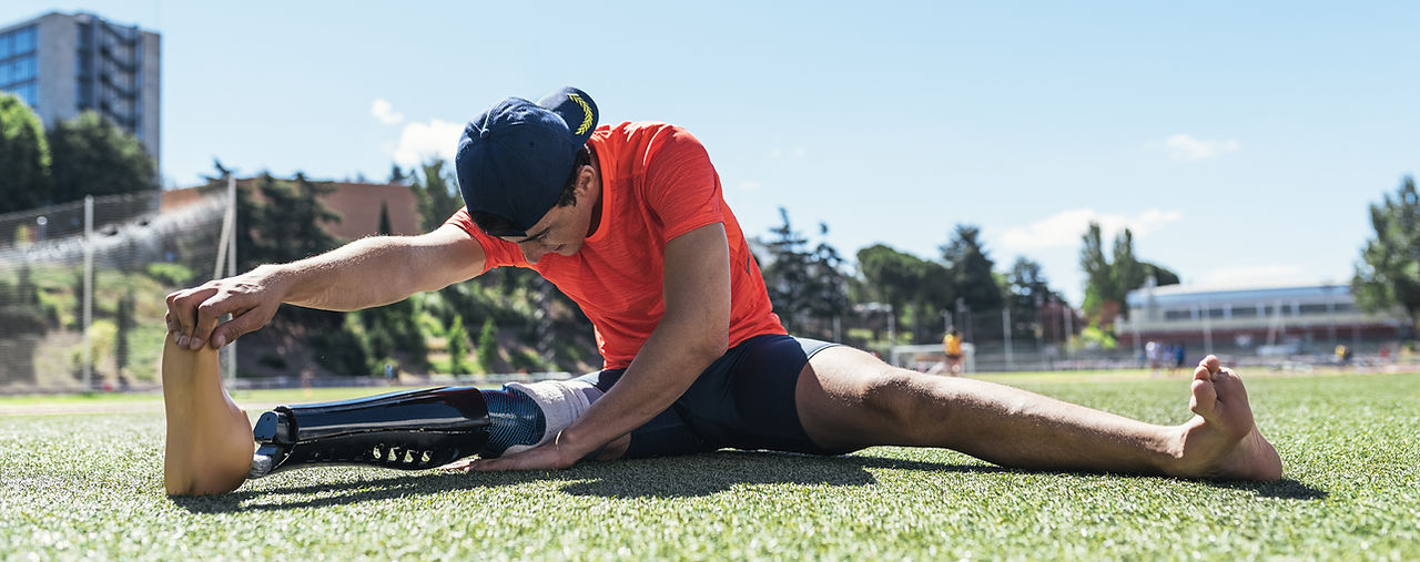 athlete strecthing with prosthetic leg
