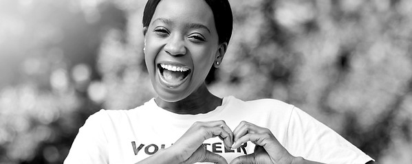 female volunteer with hands in heart shape