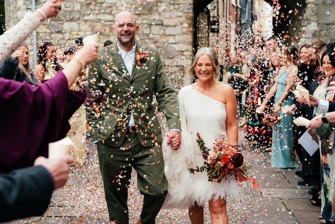 Bride and groom walking through natural confetti