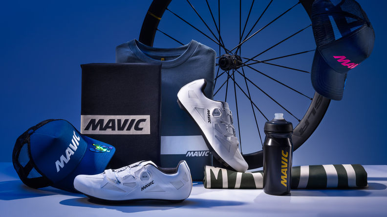 Packshot produits Mavic comprenant chaussures de vélo, textile, casquette, gourde et roue, sur fond bleu