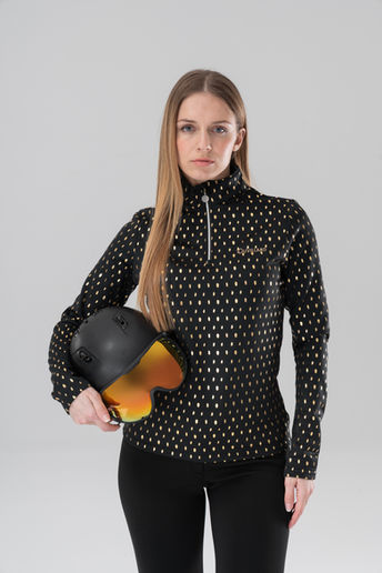 Femme en pull noir à motifs dorés tenant un casque