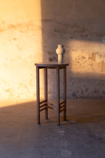 Nature morte avec vase blanc sur un tabouret en bois, éclairage artistique studio