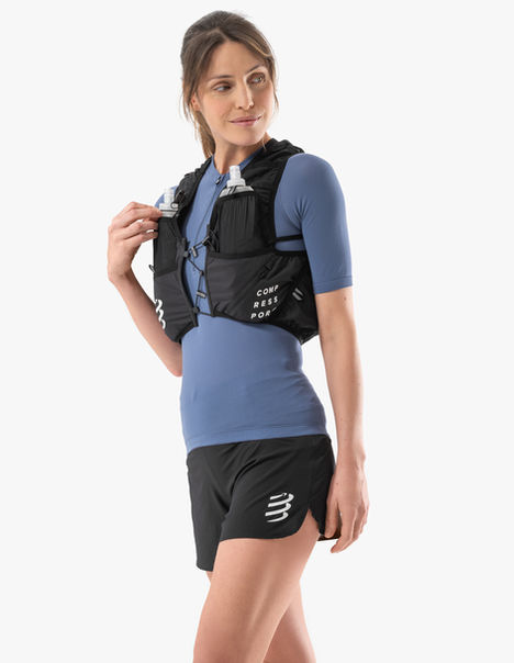Femme en t-shirt bleu avec gilet de trail Compressport noir
