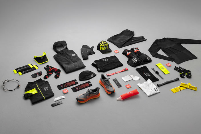 Packshot studio avec vêtements et accessoires Compressport disposés à plat