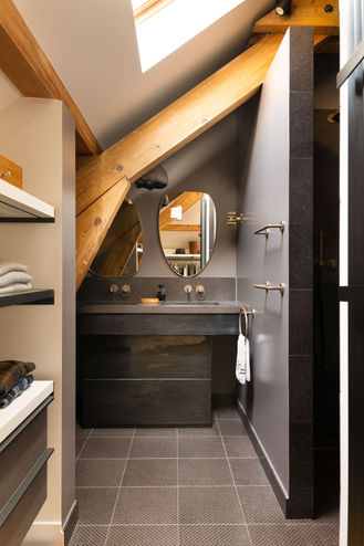 Salle de bain contemporaine sous combles avec poutres en bois et double vasque design.