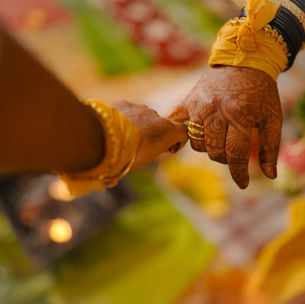 A close-up of a bride and groom joining hands during a traditional Indian wedding ceremony, capturing the intimacy, ritual, and symbolism of marriage.
