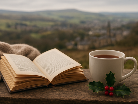 a book on a table next to a mug overlooking a yorkshire valley