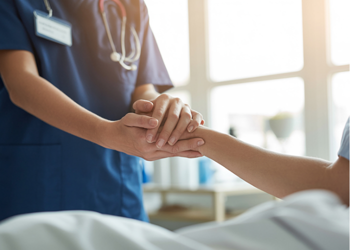 Nurse and patient holding hands and comforting each other.