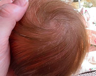 A reborn head showing a thicker rooting with baby brown mohair