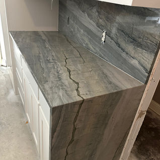 Blue quartzite kitchen countertops with matching backsplash and waterfall in Frisco, TX