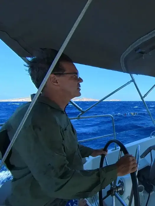 Focused man at the helm, practicing precise steering, Salty Fundamentals skill development.